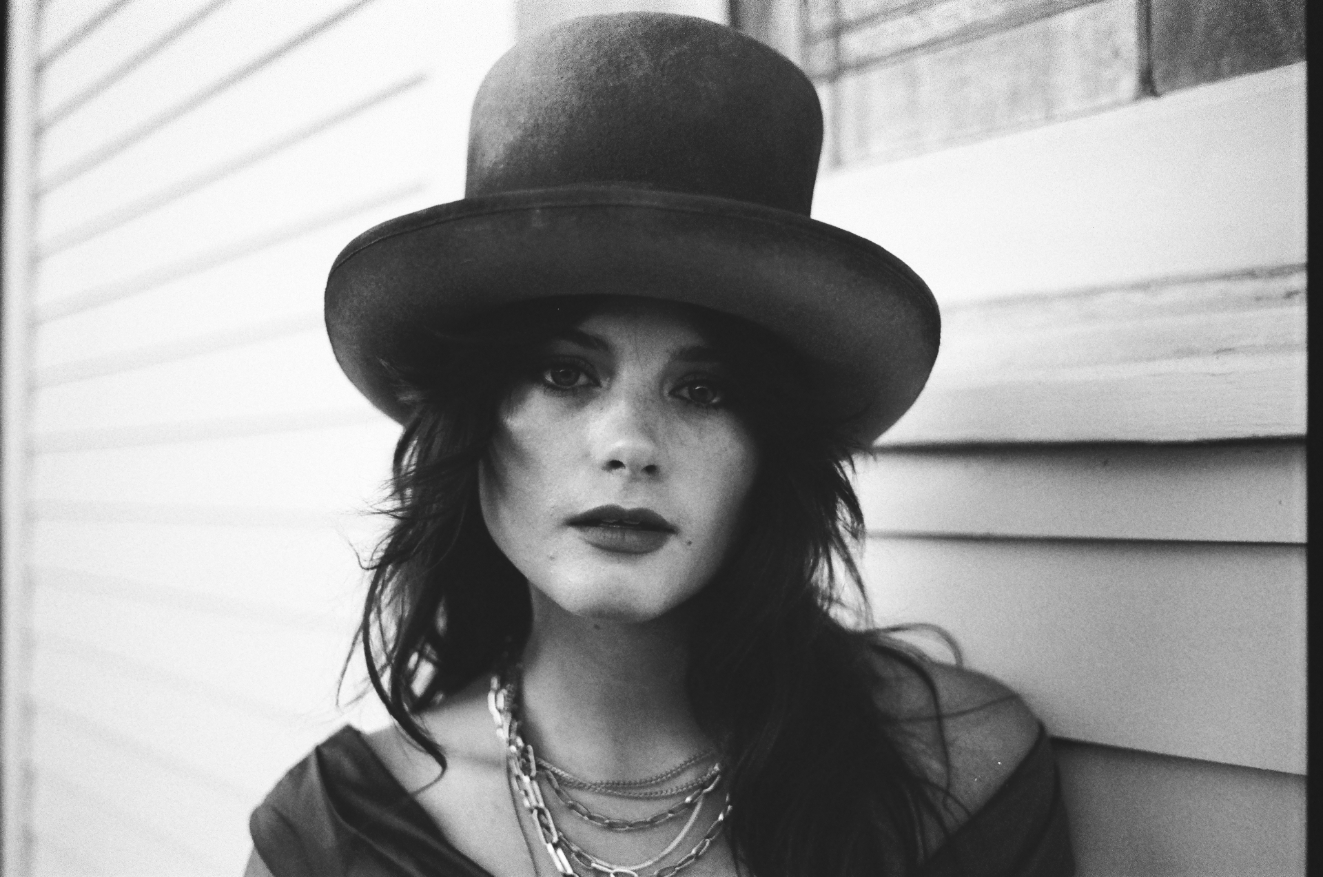 Original black and white 35mm close-up portrait of a woman in a bowler hat and layered chains