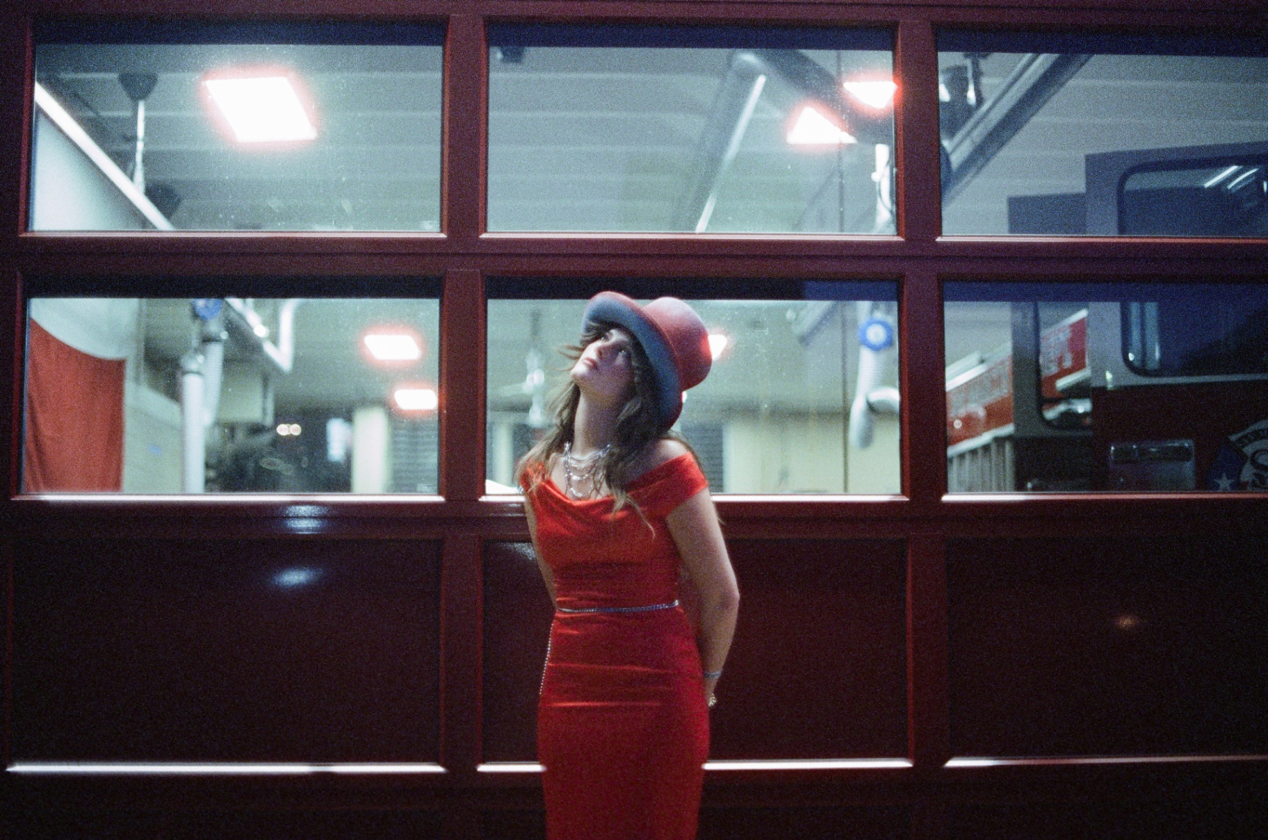 Original 35mm portrait of a woman in a red dress and hat under neon and street light